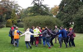 Refugees and local people singing and dancing together outdoors in park