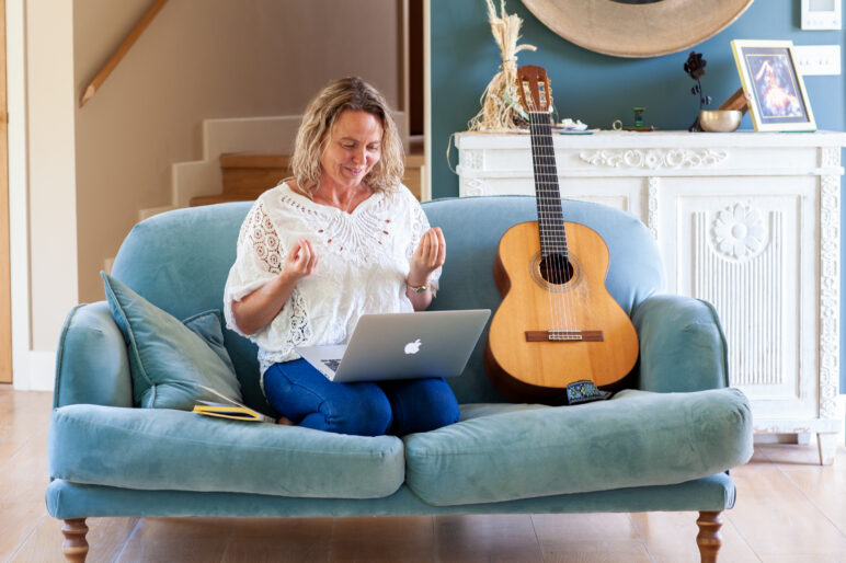 Susie Ro with laptop and guitar